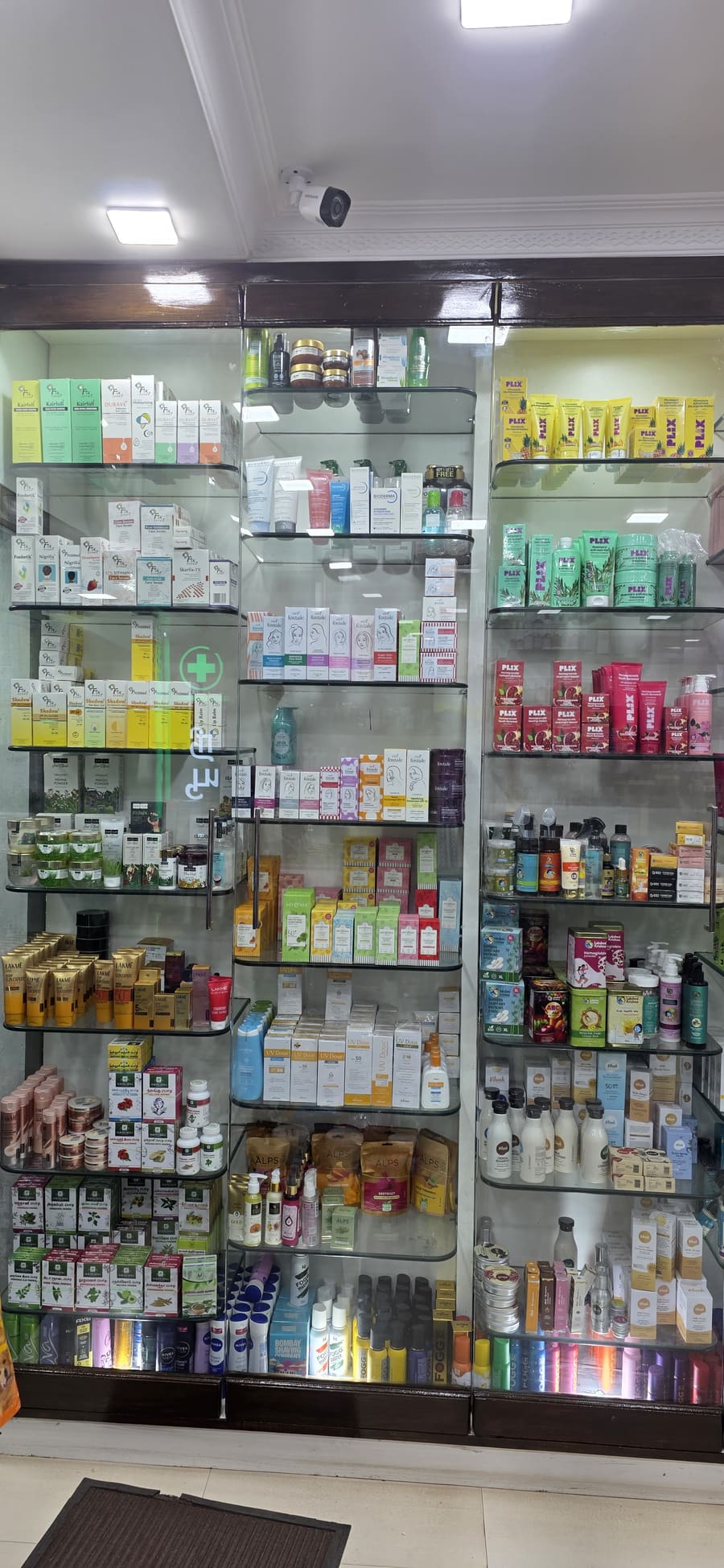 Skincare and cosmetics wall with brands like Plix, Lakme and Foxtale on lit glass shelves