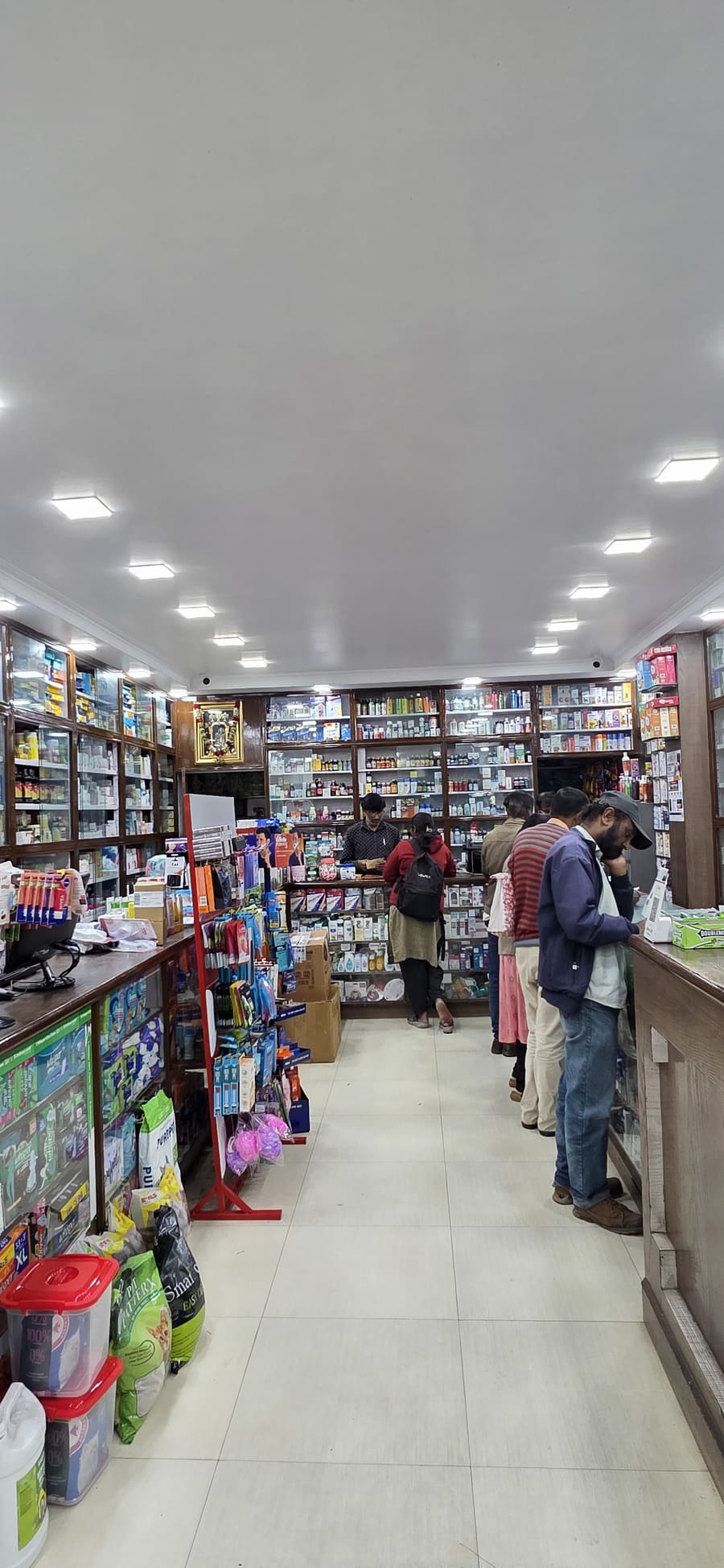 The main pharmacy counter with pharmacist and customers, Mount Road, Coonoor