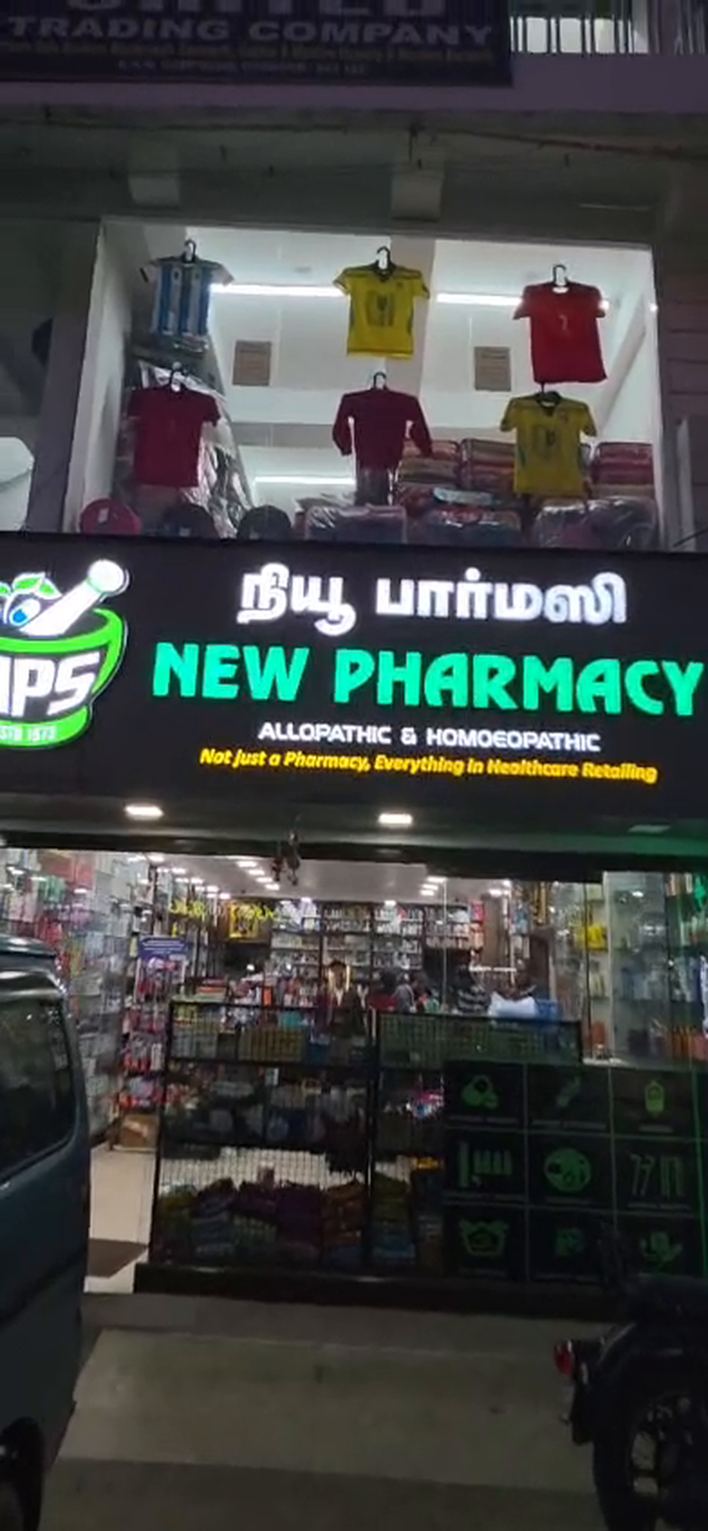 The New Pharmacy storefront on Mount Road, Coonoor, lit up in the evening